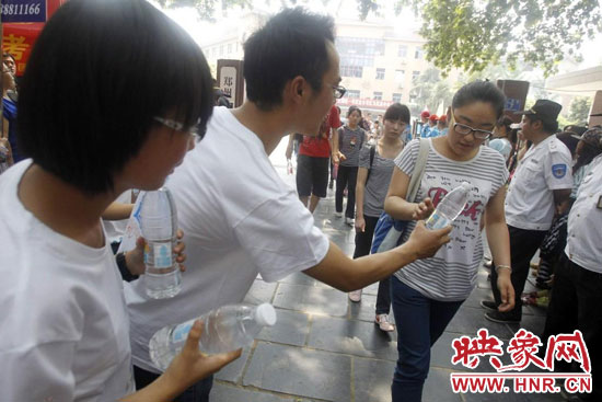 志愿者為剛剛考試完的考生送上1瓶冰凍的冰露·純悅，消暑解渴為考生加油