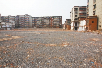 為降塵，旮旯王村拆遷后裸露的地面上鋪了一層石子。