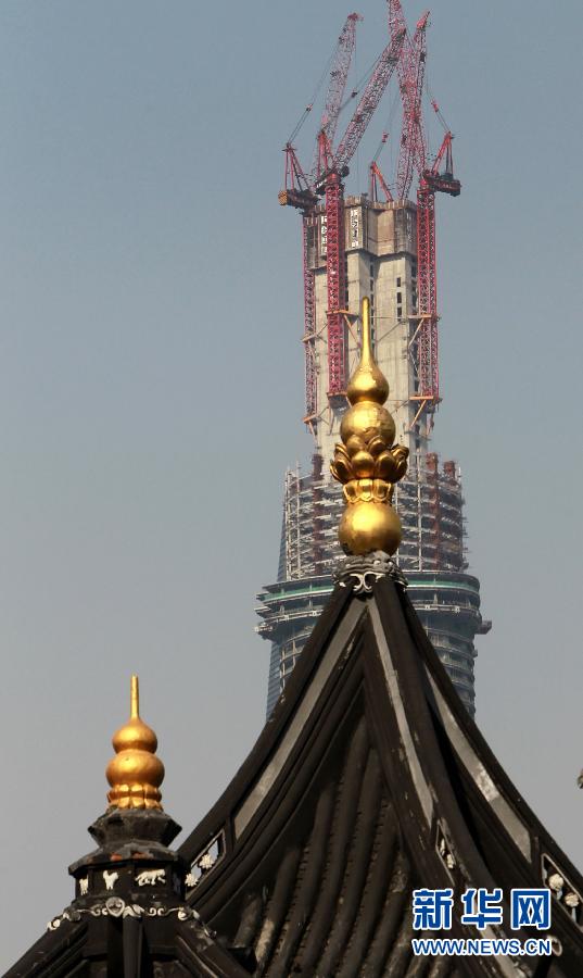 正在建設(shè)中的“上海中心”與豫園地區(qū)的傳統(tǒng)建筑（前）（4月11日攝）。