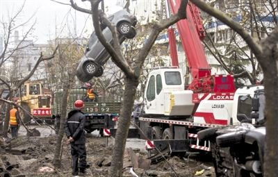 輸油管道爆炸后，搶修人員將被炸毀的車輛運出現(xiàn)場。