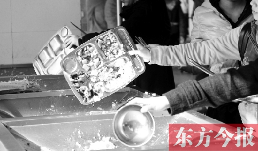 11月27日，河南中醫(yī)學(xué)院餐廳，一名同學(xué)將餐盤內(nèi)沒吃完的食物倒入餐具回收車內(nèi)