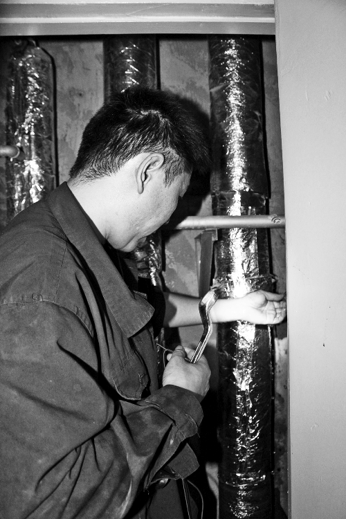 苗師傅一邊進(jìn)行維修，一邊用耳機(jī)接聽市民的電話。