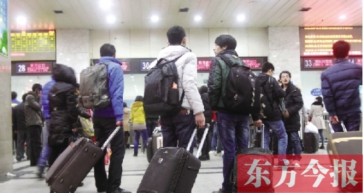 鄭州火車站東廣場售票大廳，幾名學(xué)生在售票窗口前躊躇