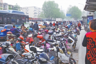 省人民醫(yī)院北門，路邊的公交站牌處停滿非機(jī)動車，上、下客只能在快車道上。