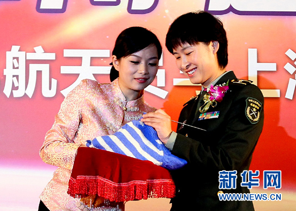 11月1日，航天員劉洋（右）在為“愛心”毛衣編織最后的收尾針。