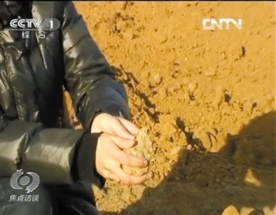 麻剛沙系麻剛石粉碎而成。記者找到一塊麻剛石，一捏就碎成粉末，硬度非常差。央視截圖