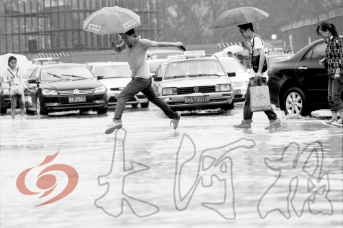 鄭州經(jīng)三路與北環(huán)交叉口處，積水較深，行人們不得不“練輕功”。 記者 白周峰 攝影