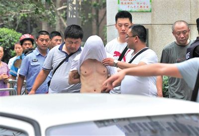 昨日，成都警方抓捕時與毒犯發(fā)生槍戰(zhàn)。一名男犯罪嫌疑人被警方押出。