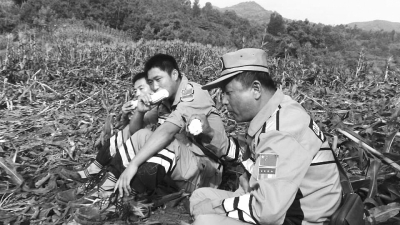 饑餓難忍，中國(guó)緊急救援河南基地的救援隊(duì)員在已毀的玉米地里撿拾生玉米吃。