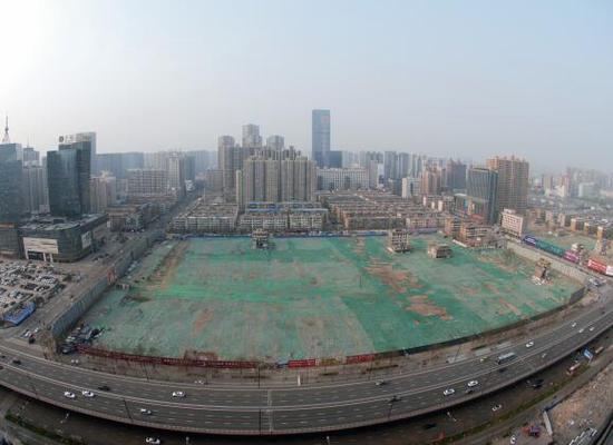 2016年4月，經(jīng)過持續(xù)攻堅，親賢社區(qū)西北片區(qū)的拆遷工作基本告一段落，但在鋪設(shè)了防塵綠網(wǎng)的空地中，至今仍有3戶居民選擇了“堅守”。(拍攝：2016年4月4日)