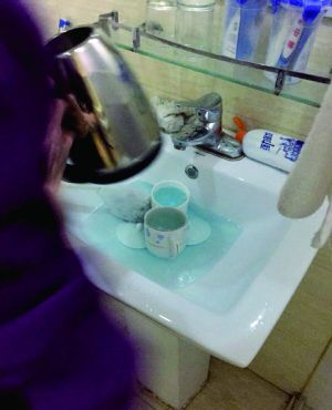 酒店服務(wù)員用潔廁液刷燒水壺和茶杯。