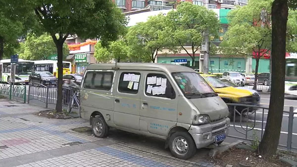 被棄置在人行道上的面包車(chē)。