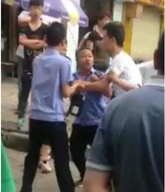 付某（右）與城管執(zhí)法人員廝打在一起。