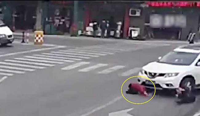 圖為小姑娘被卷進(jìn)車輪下瞬間。