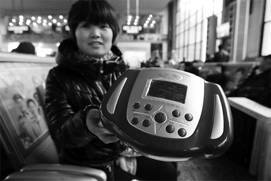火車站候車室，李女士向記者展示她準備孝敬父母的按摩儀