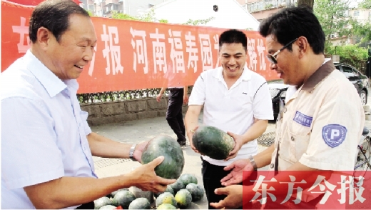 河南福壽園區(qū)域總經(jīng)理吳正宗（左一）、東方今報(bào)發(fā)行中心副總監(jiān)王路喜（中）在街頭給市民送瓜