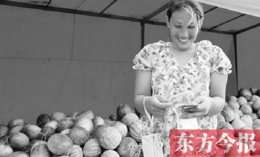 昨日，開封瓜農(nóng)史瑩瑩幸福地數(shù)著賣瓜錢 東方今報記者 沈翔 攝