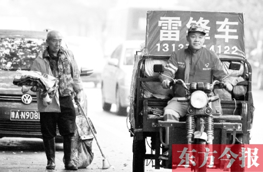 鄭州市商城路，一名環(huán)衛(wèi)工懷抱著剛剛收到的毯子，目送“雷鋒哥”孫德坤離開