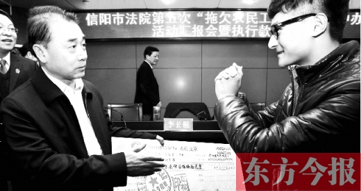 張立勇將依法執(zhí)行回來的農(nóng)民工工資發(fā)放給案件當(dāng)事人游昌華，游昌華施以中國(guó)傳統(tǒng)作揖禮答謝