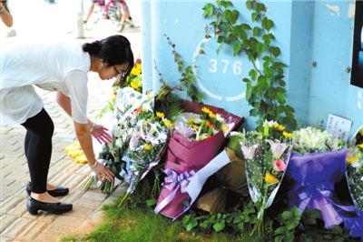 6月8日下午，記者來到廈門公交車爆炸事發(fā)現(xiàn)場橋下，附近已聚集了十幾個自發(fā)前來悼念的市民。橋墩下排放了一圈或黃或白的菊花，還有玖瑰、百合等。