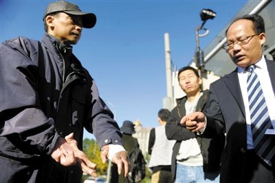 常林鋒在法院外展示雙手，他稱被燙傷的手因刑訊逼供且未得到及時救治