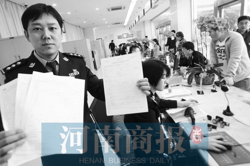 　民警左手拿的是新申請表，右手拿的是三份老申請表 王春勝/攝