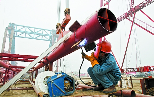 2月25日，在跨越南水北調(diào)總干渠的鄭州新鄭南段十里鋪公路橋施工現(xiàn)場，建設(shè)者在緊張地施工。