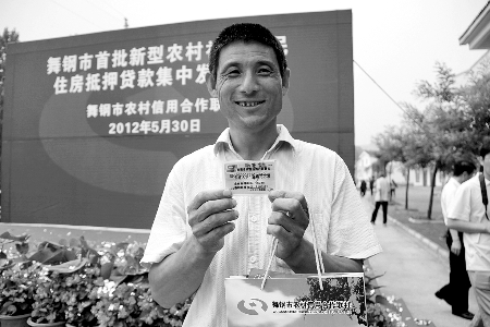 領(lǐng)到貸款，農(nóng)民開心地笑了。