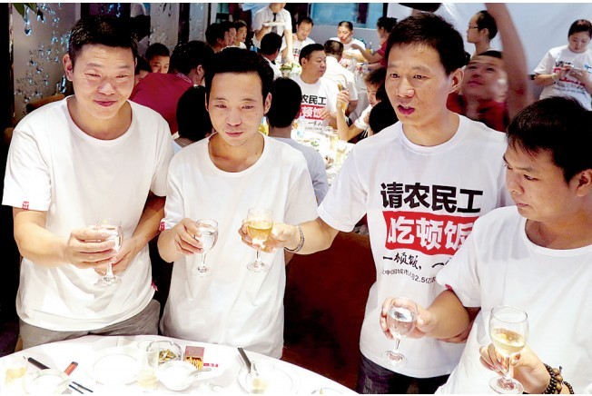 活動發(fā)起人張楠（右二）給農(nóng)民工敬酒。
