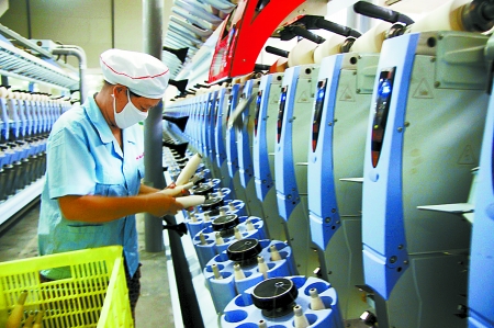 7月3日，在鄧州市永泰棉紡有限公司電腦控制全自動紡紗車間，紡織工人正在生產(chǎn)棉紗。