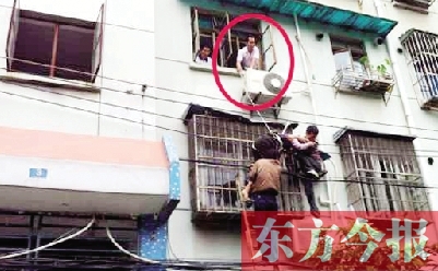 施救現(xiàn)場，劉鵬（圈內(nèi)）先用繩子捆住老太確保安全 勞動報記者 郭娜 供圖