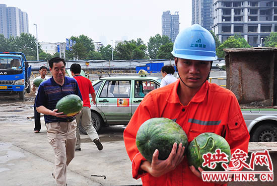 愛(ài)心的哥的姐將買來(lái)的西瓜送給工地上的工人