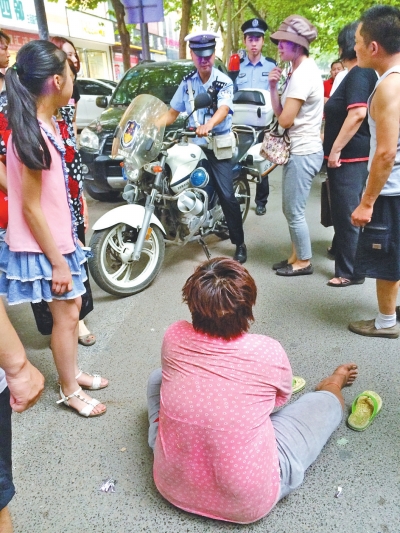 在鄭州優(yōu)勝南路東三街交叉口向東100米處，一名短發(fā)中年女子平躺在路南快車道上，身旁還有一只掉落的拖鞋
