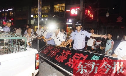 7月8日晚，鄭州市商城路一家占道經(jīng)營的攤販招牌被執(zhí)法隊員“登記保存”