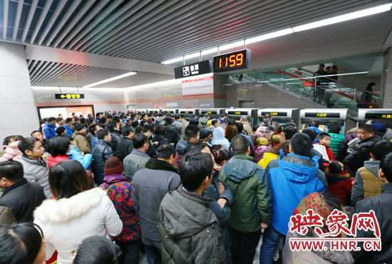 地鐵開通首日，上午十一點五十九分，紫荊山地鐵站售票機前擠滿了買票的市民。