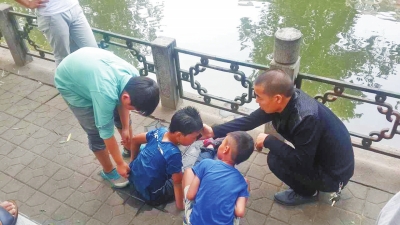 男孩被救出后，圍觀群眾幫他控水換衣服。