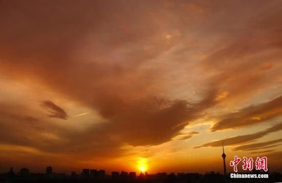 12月8日下午，強(qiáng)烈的西北風(fēng)光臨北京，吹散了籠罩全城上空的霧霾，冬日罕見(jiàn)的艷麗晚霞映紅了半邊天。