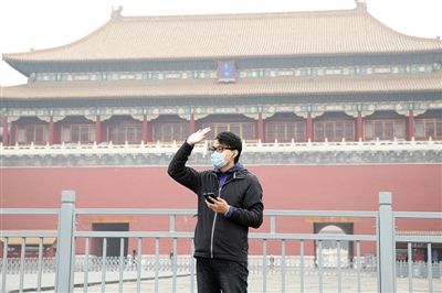 11月1日，北京大部分地區(qū)重度污染，一名游客戴著口罩在午門(mén)前揮手跟朋友打招呼。 實(shí)習(xí)生 王飛 攝