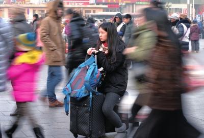 春運(yùn)首日，北京站客流量明顯增多，一名女孩在人流中等待進(jìn)站。