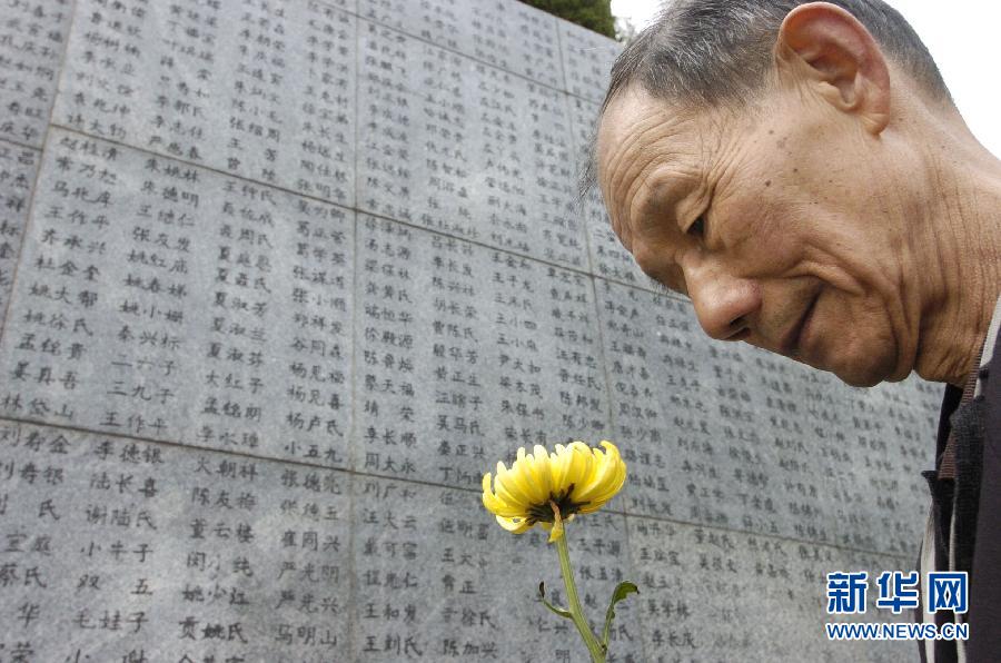 2006年4月5日，74歲的南京大屠殺幸存者佘子清手捧鮮花，祭奠被日軍殺害的母親。