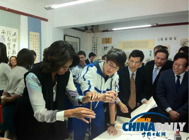 北京時間3月21日，美國第一夫人米歇爾參觀北師大二附中時，與學(xué)生一起練習(xí)書法。