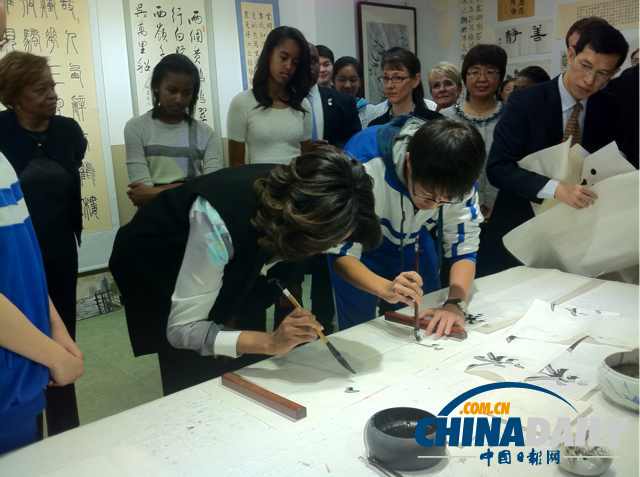 　北京時間3月21日，美國第一夫人米歇爾參觀北師大二附中時，與學(xué)生一起練習(xí)書法。