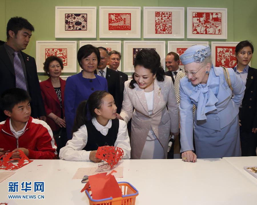 這是彭麗媛和瑪格麗特二世與根據(jù)安徒生童話中人物和情節(jié)制作剪紙的孩子交談。