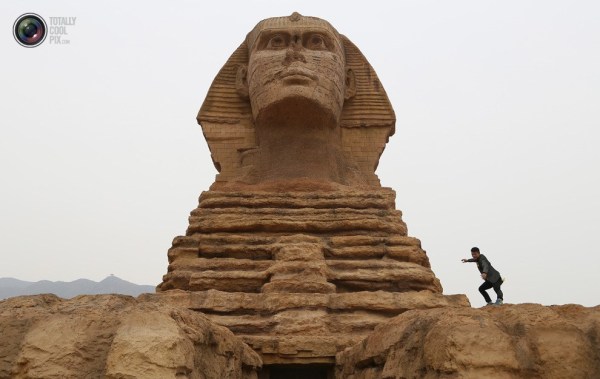 石家莊郊外，一名男子與山寨版獅身人面像合影留念。