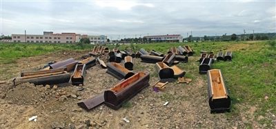40多副棺木被砸壞后，扔在荒地上。