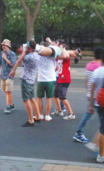 　四名外籍男子一同扛起醉漢拍照。