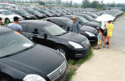 昨日，市民在山東棗莊一家拍賣公司場(chǎng)地上查看待拍賣公車。當(dāng)日，棗莊市103輛公車公開拍賣。新華社記者
