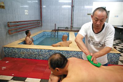 客人在搓澡。近日，百年歷史的鑫園浴池宣布將關(guān)張。新京報記者