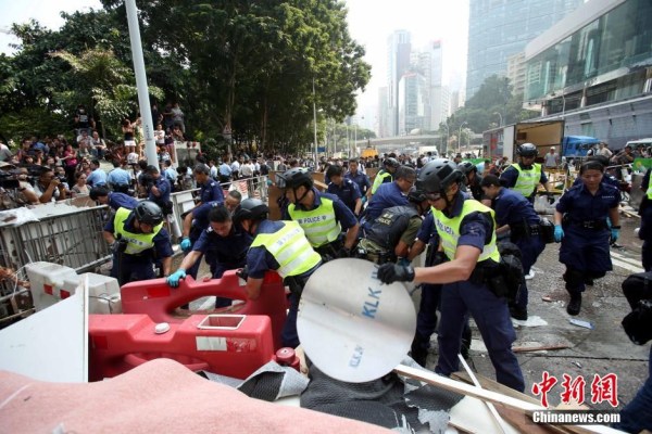 10月14日，警方清除金鐘道障礙物。大批警員在金鐘道現(xiàn)場清拆障礙物。部分警員戴上頭盔將障礙物移走。