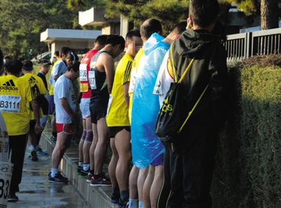 2013年10月20日，北京馬拉松比賽，由于廁位有限，一些選手在綠化帶“就地解決”。圖/IC